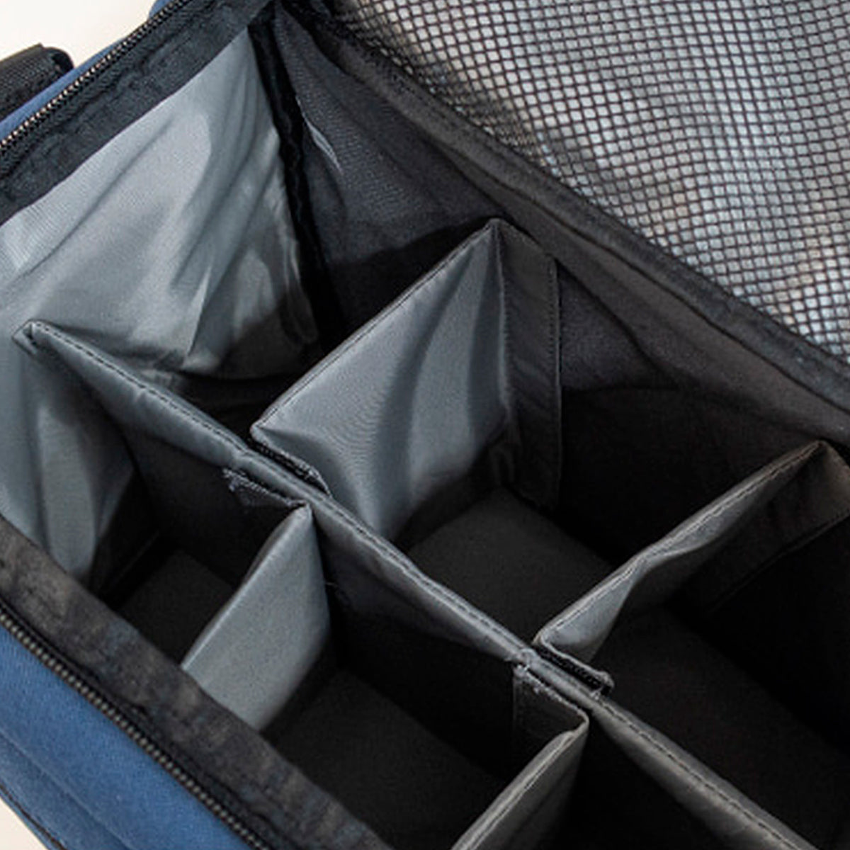 Close-up of a blue and black zippered organizer case with multiple interior compartments and a mesh pocket lining.