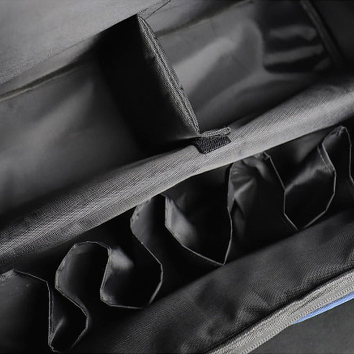 Close-up of a dark gray fabric organizer pouch with multiple compartments and elasticized pockets.